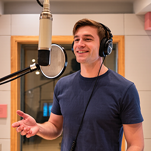 Picture of a male voice talent in the voice over booth.